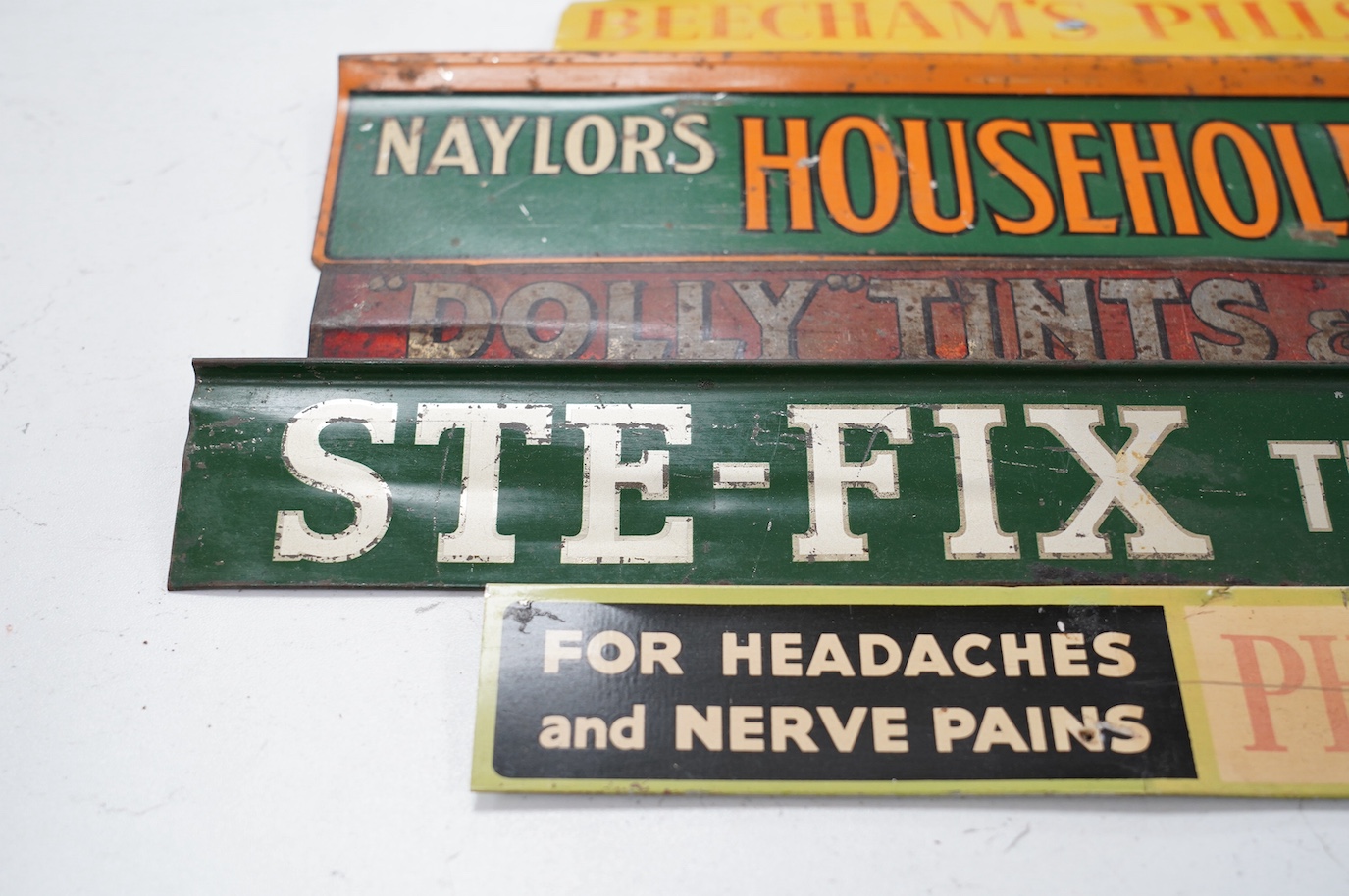 Eleven early / mid century tinplate advertising shelf strips, largest 60cm. Condition - poor to fair